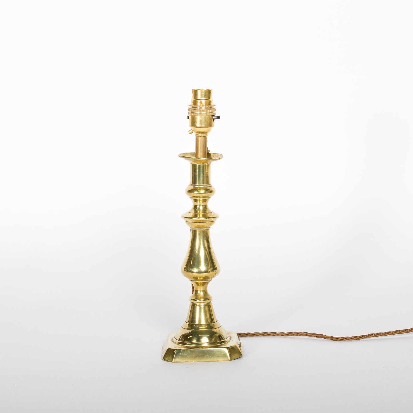 A pair of brass candlesticks converted to lamps, circa 1850