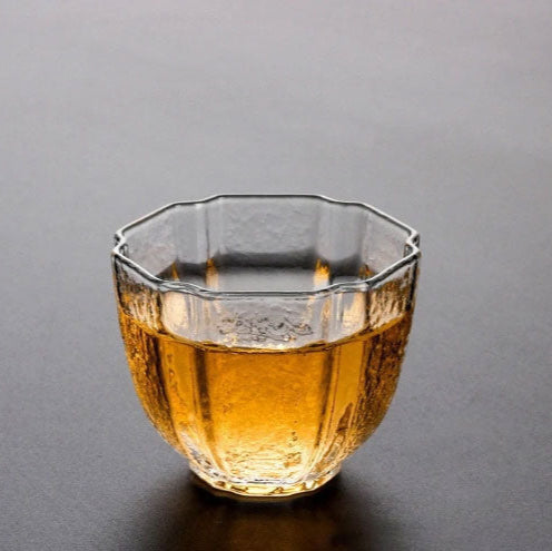 Glass filled with amber liquid on a gray background
