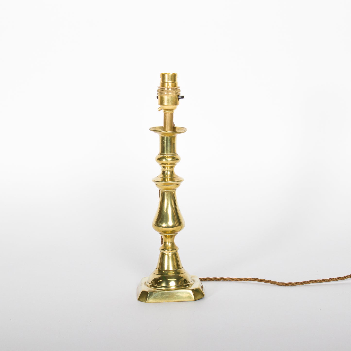 A pair of brass candlesticks converted to lamps, circa 1850